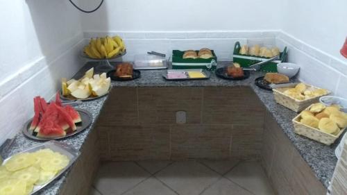 a buffet with different types of food on a counter at Pousada Balbino in Cabo Frio