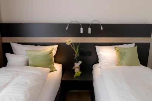 two beds sitting next to each other in a room at Hotel Campo in Renningen