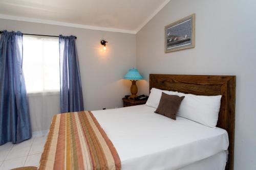 a bedroom with a bed and a window at South Coast Horizon in Curtain Bluff