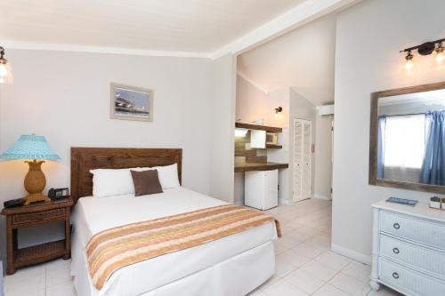 a white bedroom with a bed and a window at South Coast Horizon in Curtain Bluff