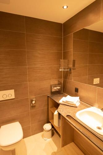 a bathroom with a toilet and a sink at Hotel Campo in Renningen