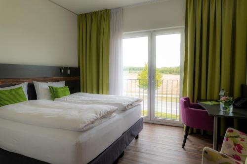 a hotel room with a bed and a large window at Hotel Campo in Renningen