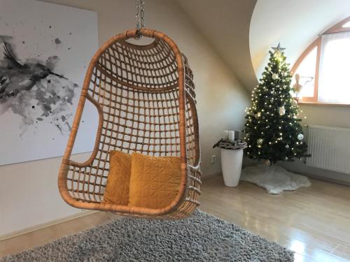 a wicker swing in a living room with a christmas tree at Sv. Petr (St. Peter) in Plzeň