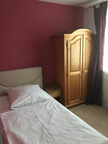 a bedroom with a bed and a wooden cabinet at Hotel Zum Weinberg in Cremlingen