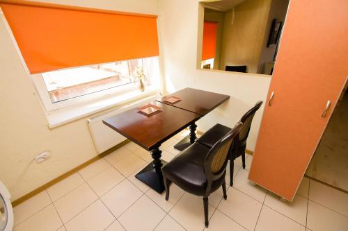 a dining room table with black chairs and a window at Old Town Apartments in Alytus