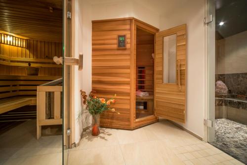 a walk in shower with a vase of flowers in a room at Landhaus Lexner in Tux