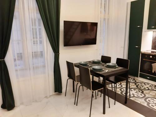 Un comedor con una mesa y sillas negras. en Danube Elegance Apartment, en Budapest