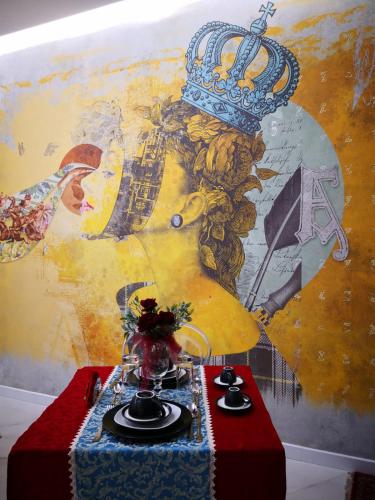 een tafel met een muurschildering van een persoon met een kroon bij Luxury B&B Charlemagne in Salerno