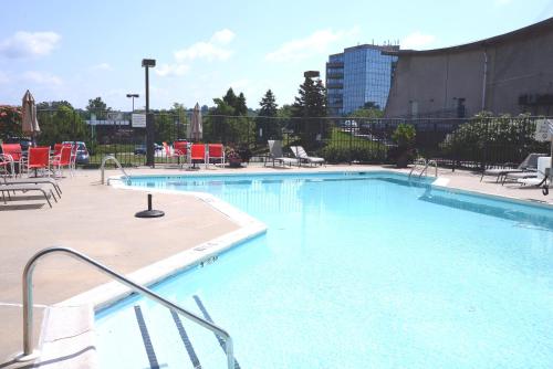 a large blue swimming pool with chairs and tables at Holiday Inn Timonium by IHG in Timonium