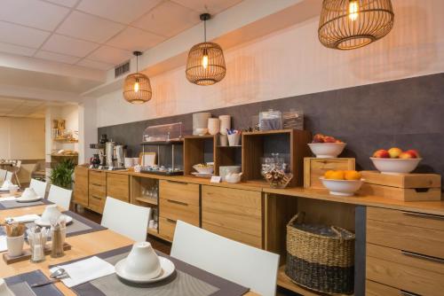 a restaurant with a table and chairs and pendant lights at Hotel Le Richemont in Paris