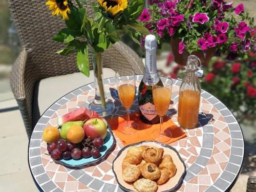 a table topped with plates of fruit and orange juice at Kalypso View Apartments in Letimbou
