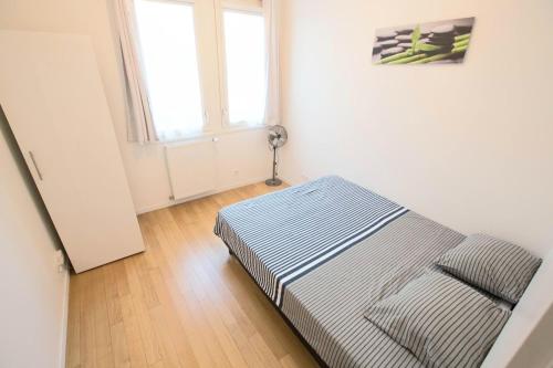 a bed sitting in a room with a window at Location F3 Fontenay-Aux-Roses in Fontenay-aux-Roses
