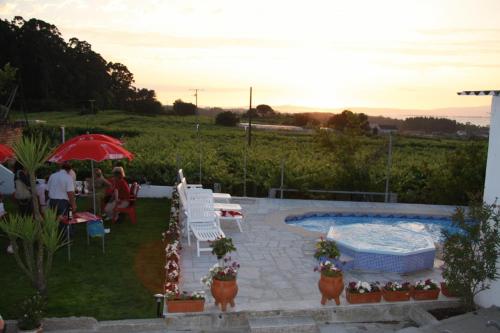 um quintal com uma piscina, uma mesa e cadeiras em O Lar da Avoa em Cambados