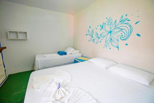 a room with two beds and a painting on the wall at Pousada Sunset Boipeba in Ilha de Boipeba