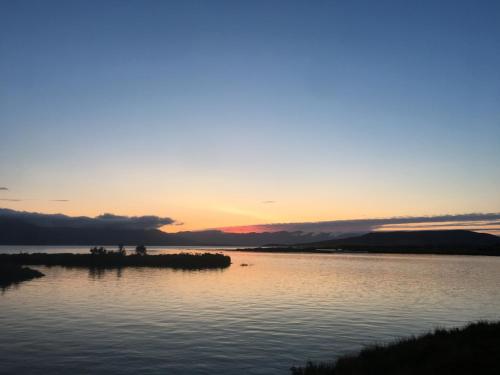a sunset over a body of water at Áshóll guesthouse - farmstay in Akureyri