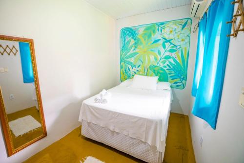 a small room with a bed and a mirror at Pousada Sunset Boipeba in Ilha de Boipeba