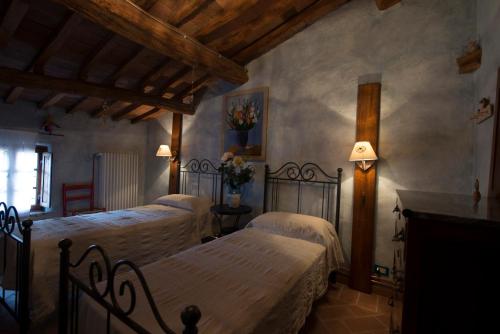 a bedroom with two beds and a fireplace at Casa Benoi in Rigomagno