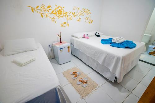 a bedroom with two beds and two pairs of shoes at Pousada Sunset Boipeba in Ilha de Boipeba