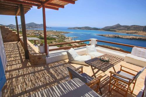 a balcony with a table and chairs and the ocean at Antiparos Vibes in Agios Georgios