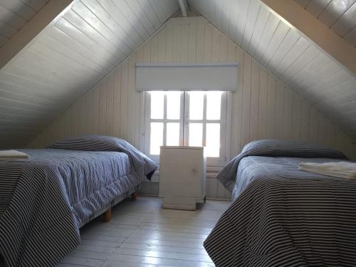 Habitación en el ático con 2 camas y ventana en Las Huellas Cabaña, en Balneario Pehuén-Có