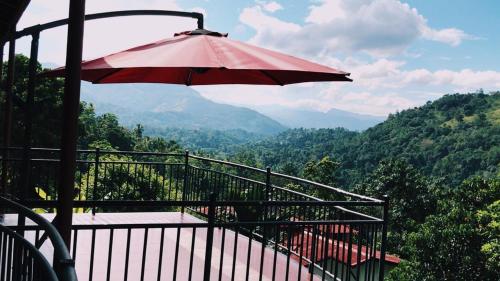 a red umbrella sitting on top of a balcony at The Springfields Kandy Previously Madara Residence Kandy in Kandy