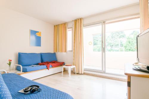 une chambre avec un lit bleu et une grande fenêtre dans l'établissement Résidence Villa Livia, à Cannes