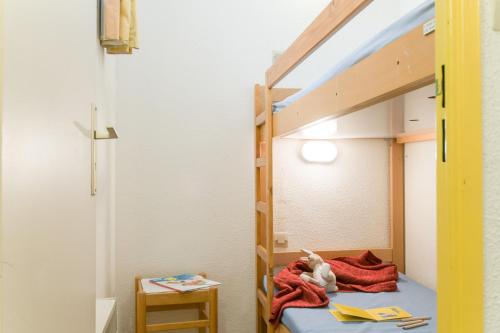 - un petit chien assis sur une couverture dans un lit superposé dans l'établissement Résidence Villa Livia, à Cannes