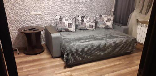 a bedroom with a bed with pillows and a table at Apartment 30 m2 on Sergei Esenin 11 in Kharkiv