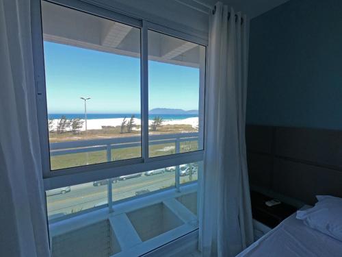 une chambre avec une fenêtre avec vue sur l'océan dans l'établissement PRAIA DO FORTE - PÉ NA AREIA - 6 hóspedes, à Cabo Frio