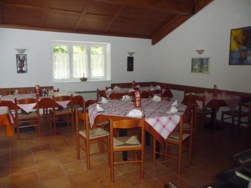 uma sala de jantar com mesas e cadeiras com guardanapos vermelhos e brancos em B&B Tre Faggi em Borgo