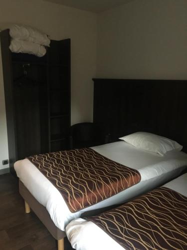 une chambre avec un grand lit avec une tête de lit noire dans l'établissement Kyriad Rodez, à Rodez