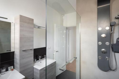 ein weißes Badezimmer mit einem Waschbecken und einem Spiegel in der Unterkunft Le Hauban by Cocoonr in Saint-Malo