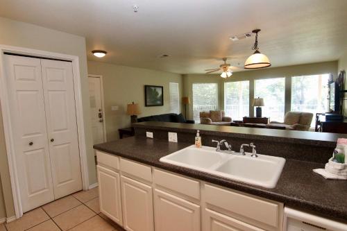 eine Küche mit Spüle und ein Wohnzimmer in der Unterkunft Guadalupe Dew Drop Inn in New Braunfels