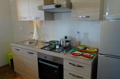a kitchen with a stove top oven next to a refrigerator at casa vacanze, via delle margherite 3 in Montecorvino Pugliano