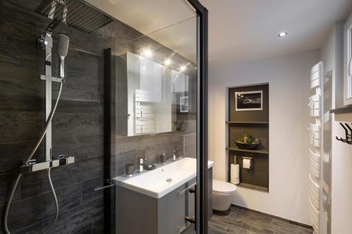 une salle de bain avec un lavabo blanc et une douche dans l'établissement Le Deriveur by Cocoonr, à Saint-Malo
