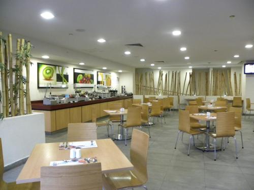 a restaurant with tables and chairs and a counter at Holiday Inn Express Guadalajara Expo, an IHG Hotel in Guadalajara