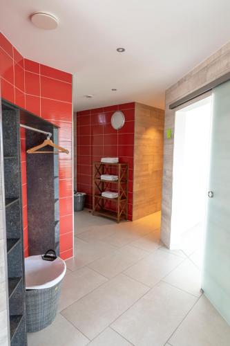 a bathroom with a tub and a red wall at Hotel Campo in Renningen