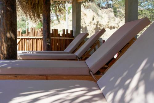 a group of lounge chairs sitting on a porch at Hospedaje La Quebrada in Máncora