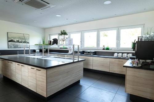 a large kitchen with a large island in the middle at Hotel Campo in Renningen