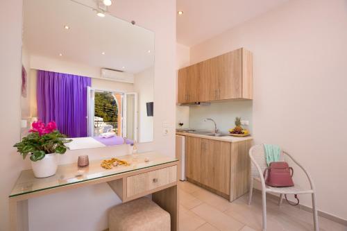 a kitchen with a desk and a purple window at Alexander in Agios Gordios