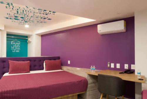 a room with two beds and a purple wall at Hotel Bonn in Mexico City