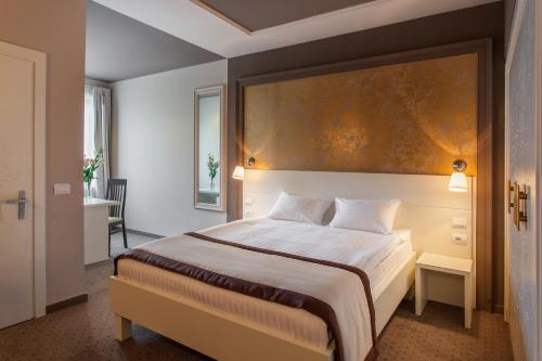 a bedroom with a bed with a large painting above it at Continental Hotel in Odesa