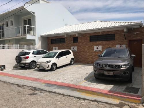 two cars parked in a parking lot in front of a building at Casa - Próximo a UFSC e CENTRO - 5 KM in Florianópolis