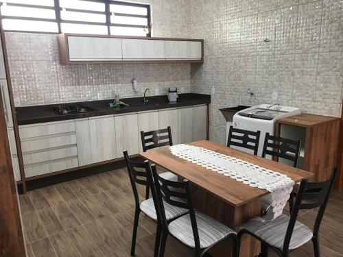 een keuken met een houten tafel en stoelen en een wastafel bij Casa - Próximo a UFSC e CENTRO - 5 KM in Florianópolis