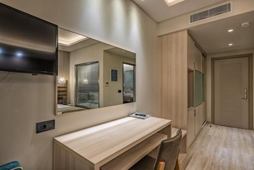 a bathroom with a large mirror on the wall at Alexandra Beach Resort & Spa in Tsilivi