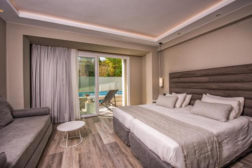 a bedroom with a large bed and a couch at Alexandra Beach Resort & Spa in Tsilivi