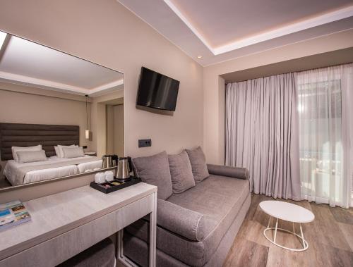 a living room with a couch and a bed at Alexandra Beach Resort & Spa in Tsilivi
