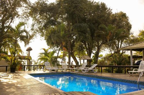 a swimming pool with two chairs and a table at Chalés do Laurindo in Maciel