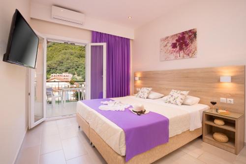 1 dormitorio con 1 cama grande y TV en Alexander en Agios Gordios