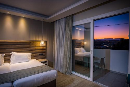 a hotel room with a bed and a large window at Alexandra Beach Resort & Spa in Tsilivi